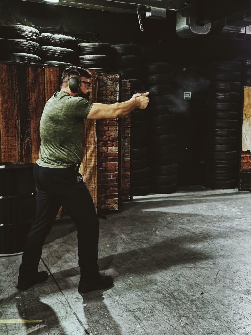 Atirador em treino de pistola na linha de fogo do estande